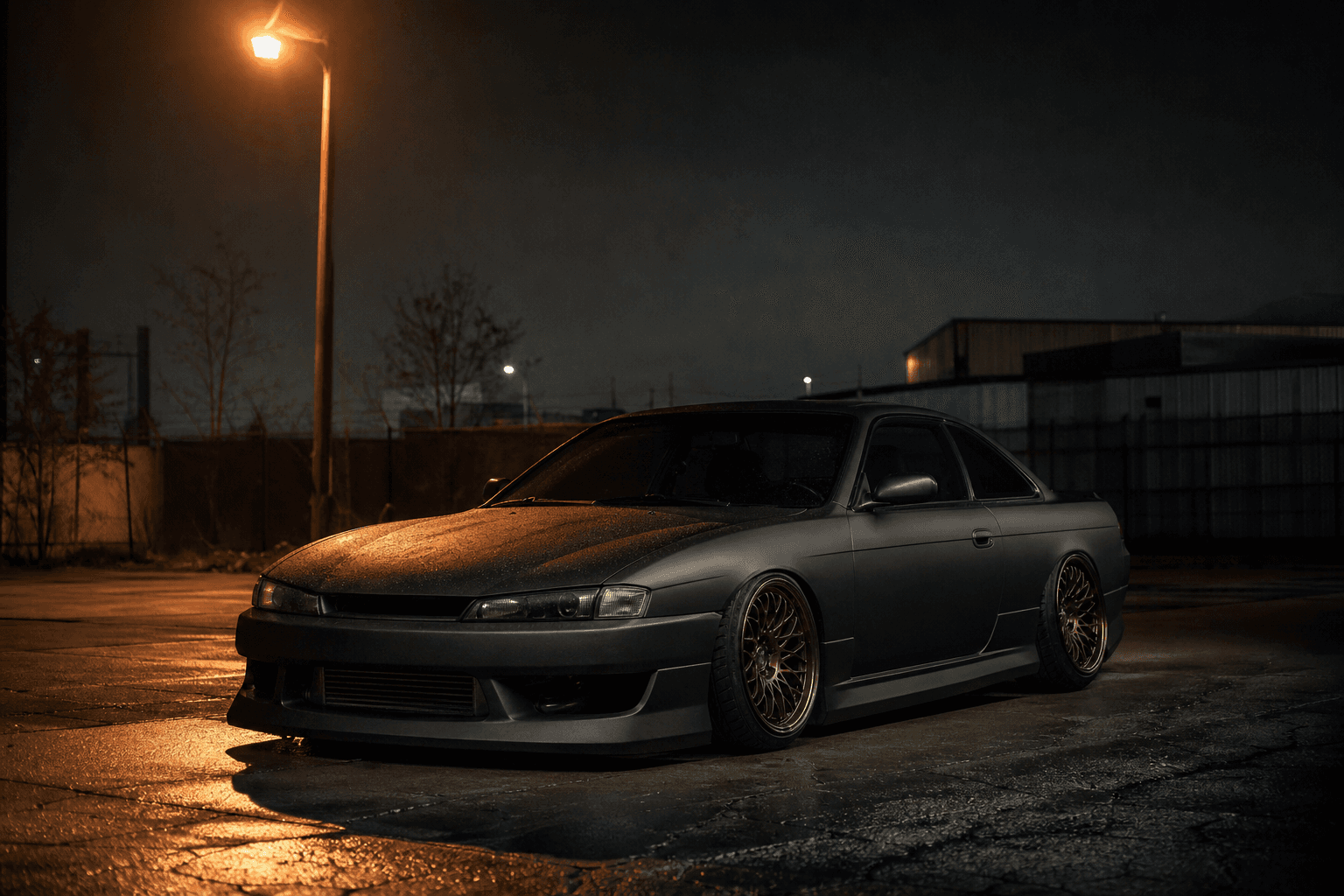 A slammed 1998 Nissan Silvia S14 under a sodium streetlight on wet asphalt at night